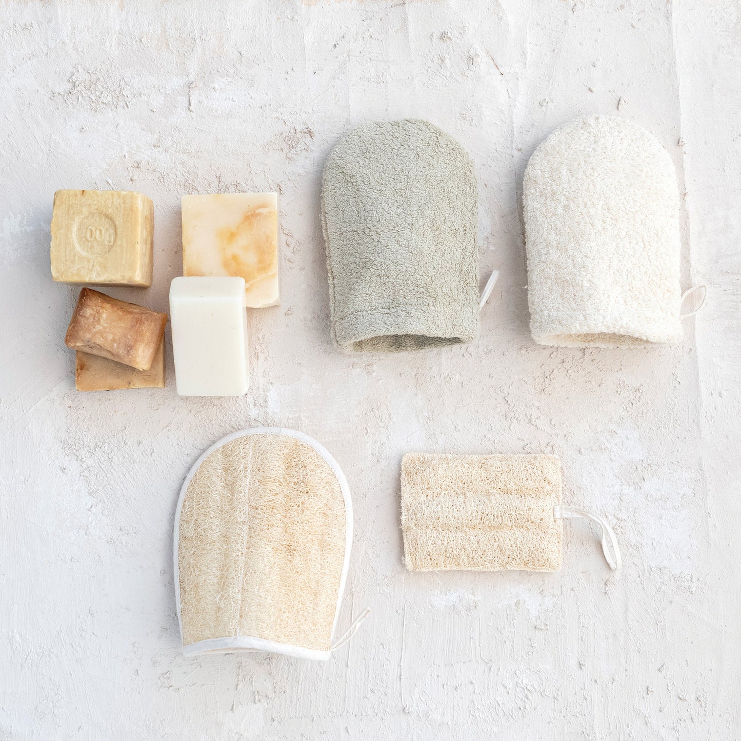 Natural Exfoliating Loofah Pad with Hanging Loop for Self Care in Bath or Shower styled with other self care products and soap bars