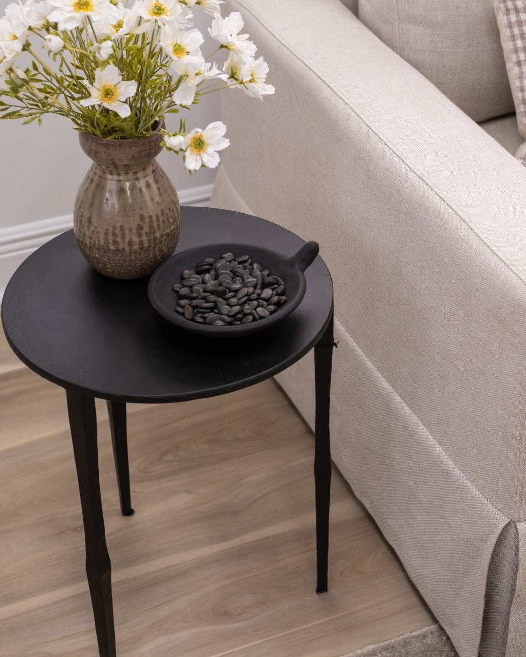 Cairo Ebony Black Matte Iron Modern Minimalist Slender Side Table Styled with Vase and Decorative Bowl with River Stones