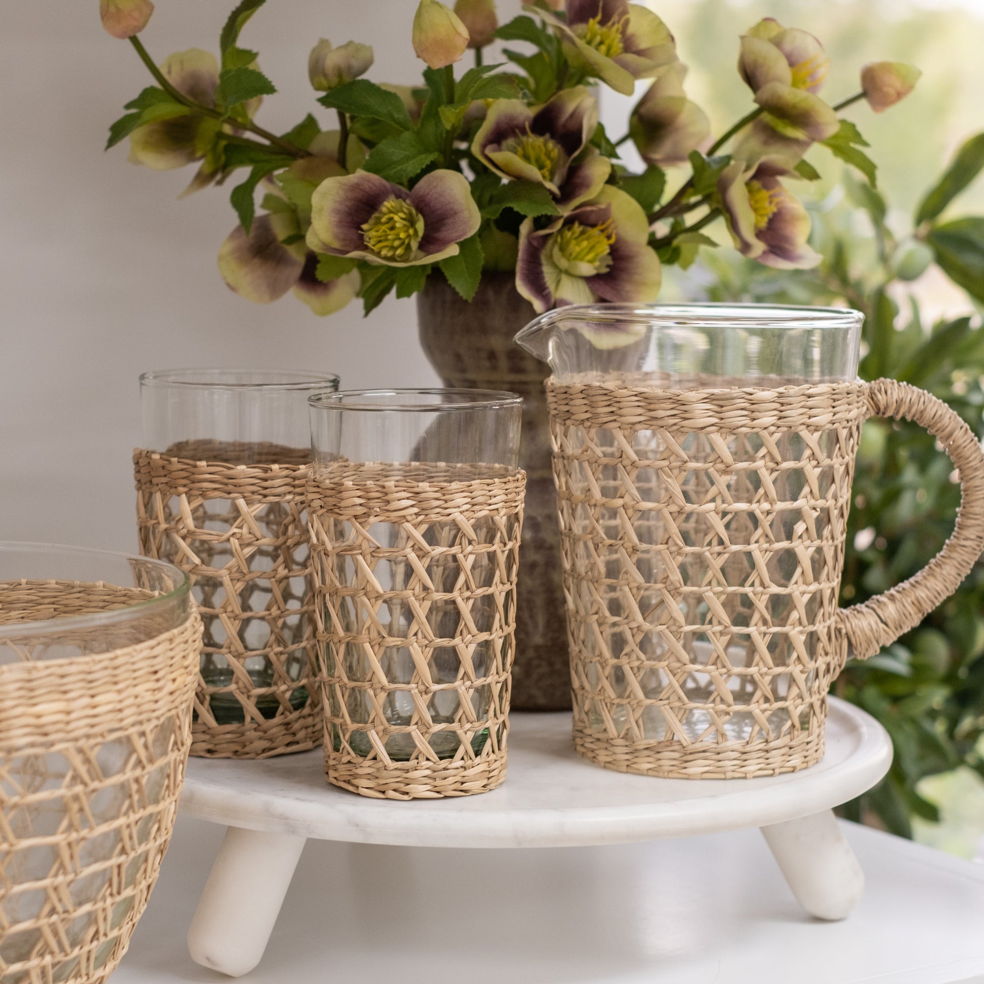 Glass Pitcher with Light Natural Woven Seagrass Cage Wrap and Highball Glasses Styled on Tray