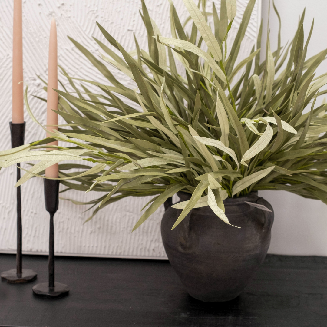 Tolar Matte Black Terracotta Vase holding Green Faux Dune Grass on Console with Pink Taper Candles